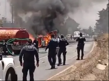 Patrulla incendiándose frente a policías en Acaxochitlán, en Hidalgo