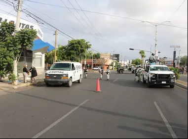 Elementos del Ejército parados al lado de su patrulla y personal de Semefo atendiendo una emergencia en calles de Sinaloa