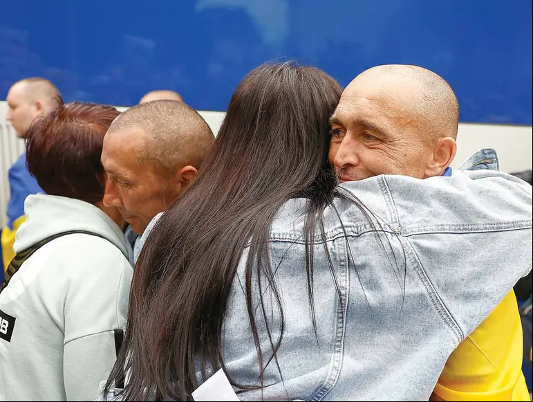 Prisioneros ucranianos liberados abrazándose con sus familiares.