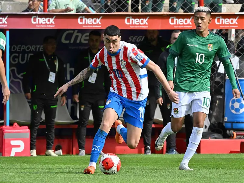 Miguel Almirón driblando a un defensa de Bolivia.