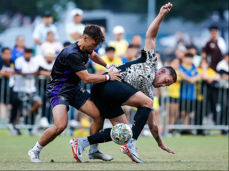 Jugadores de América y The 610 disputando el balón.
